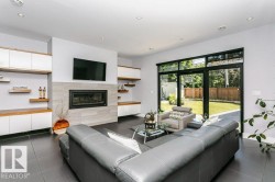 Living area featuring a floor-to-ceiling fireplace with light-toned tile surround, integrated shelving, and dark tile flooring - 