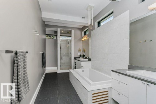 Modern bathroom featuring a built-in soaking tub and a separate glass-enclosed shower - 9035 Saskatchewan Drive, Edmonton, AB 
