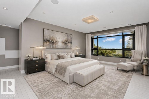 Expansive room featuring a large window with black framing, light wood-finish flooring, recessed ceiling lighting, and a contemporary ceiling fixture - 9035 Saskatchewan Drive, Edmonton, AB 