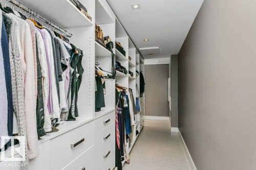 Custom built-in closet system featuring multiple hanging rods, shelving units, and drawer storage with contemporary pulls - 9035 Saskatchewan Drive, Edmonton, AB 