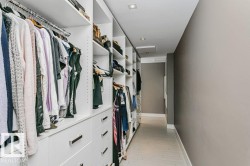 Custom built-in closet system featuring multiple hanging rods, shelving units, and drawer storage with contemporary pulls - 