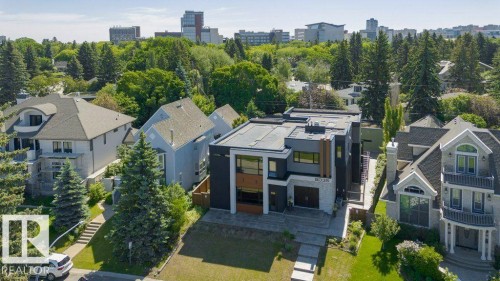 Modern architectural exterior featuring a flat roofline, dark paneling, and light-toned stone accents - 9035 Saskatchewan Drive, Edmonton, AB 