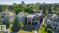 Modern architectural exterior featuring a flat roofline, dark paneling, and light-toned stone accents - 