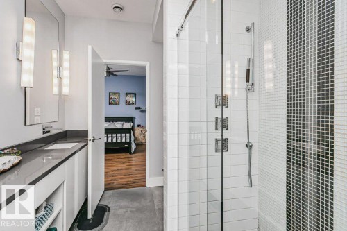 Contemporary bathroom featuring a glass-enclosed shower with wall-mounted fixtures - 9035 Saskatchewan Drive, Edmonton, AB 