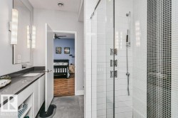 Contemporary bathroom featuring a glass-enclosed shower with wall-mounted fixtures - 