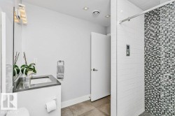 Bathroom featuring a frameless glass shower enclosure with white subway tile and a mosaic tile accent wall - 