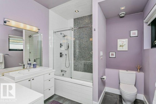 Bathroom featuring a glass-enclosed tub/shower with mosaic tile accent, white subway tile surround, a built-in vanity with integrated sink, and recessed lighting - 9035 Saskatchewan Drive, Edmonton, AB 