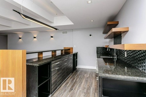 Wet bar featuring granite countertops, a built-in sink, and a mosaic tile backsplash - 9035 Saskatchewan Drive, Edmonton, AB 