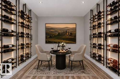 Dedicated wine room featuring floor-to-ceiling storage racks with integrated backlighting, wood-finish flooring, recessed ceiling lighting, and light-toned wall finishes - 9035 Saskatchewan Drive, Edmonton, AB 