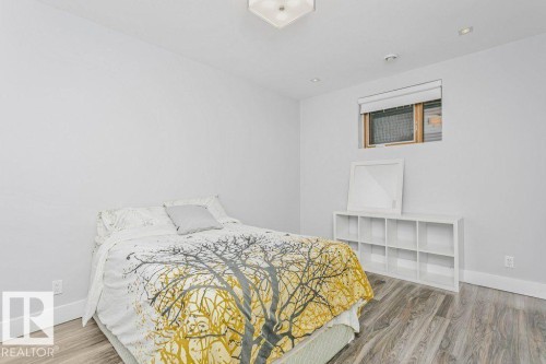 Room featuring light wood-finish flooring, white walls, and a window with blinds - 9035 Saskatchewan Drive, Edmonton, AB 