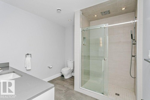 Contemporary bathroom featuring a spacious glass-enclosed shower with horizontal tile surround and tiled floor - 9035 Saskatchewan Drive, Edmonton, AB 