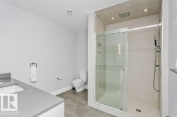 Contemporary bathroom featuring a spacious glass-enclosed shower with horizontal tile surround and tiled floor - 