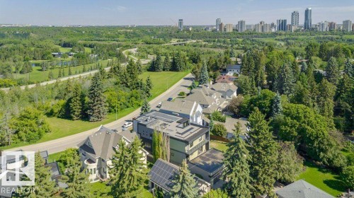 Aerial perspective showcasing a residential area amidst extensive green spaces and mature trees - 9035 Saskatchewan Drive, Edmonton, AB 