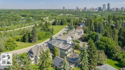 Aerial perspective showcasing a residential area amidst extensive green spaces and mature trees - 