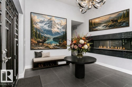 Entryway featuring a linear fireplace with glass enclosure and dark tile surround - 9035 Saskatchewan Drive, Edmonton, AB 
