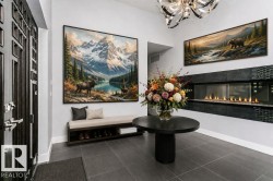 Entryway featuring a linear fireplace with glass enclosure and dark tile surround - 
