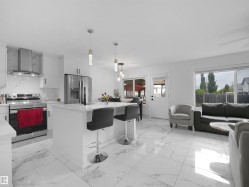Open-concept living space with large format white tile flooring - 