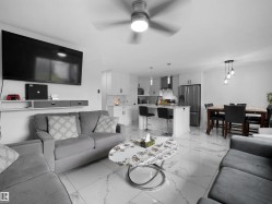 Open-concept living space featuring white marble-effect tile flooring throughout - 
