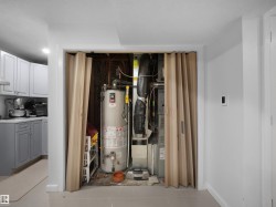 Utility closet with a water heater and HVAC system, featuring a bi-fold door - 