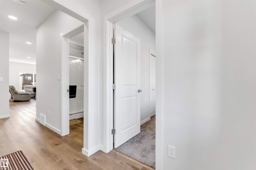 Hallway featuring light wood-finish flooring, white walls, recessed lighting, and white trim - 788 Mattson Drive, Edmonton, AB 