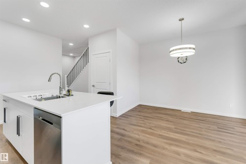 Modern kitchen island with a stainless steel sink, gooseneck faucet, and integrated dishwasher - 788 Mattson Drive, Edmonton, AB 
