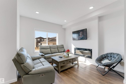 Bright living area featuring wood-finish flooring, recessed lighting, and a prominent window - 788 Mattson Drive, Edmonton, AB 