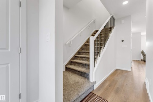 Staircase featuring dark metal balusters and a white handrail - 788 Mattson Drive, Edmonton, AB 