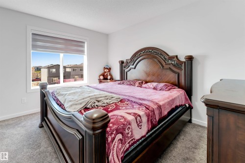 Bright room featuring a large window with horizontal shades, neutral gray carpeting, and white painted walls - 788 Mattson Drive, Edmonton, AB 