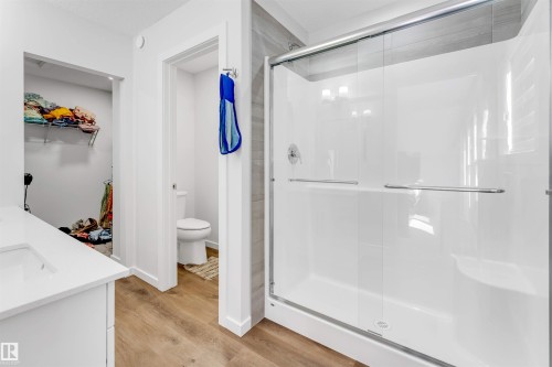 Walk-in shower with sliding glass doors, white acrylic base, and tiled surround - 788 Mattson Drive, Edmonton, AB 
