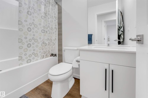 White vanity with a built-in sink, chrome faucet, and rectangular mirror - 788 Mattson Drive, Edmonton, AB 