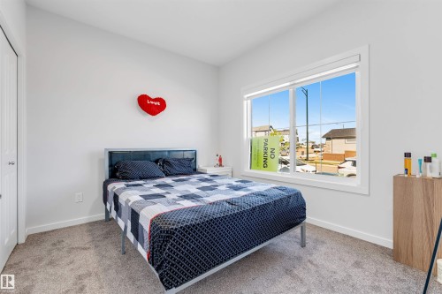 Bedroom featuring neutral-toned carpet flooring and a large window with white trim - 788 Mattson Drive, Edmonton, AB 