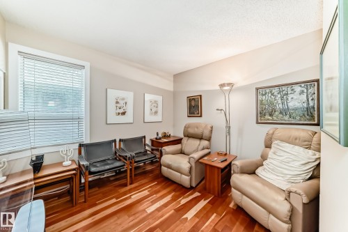 Hardwood flooring throughout, neutral paint palette, and a window with horizontal blinds - 7930 111 Street, Edmonton, AB - Indoor Photo Showing Living Room