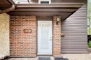 Entryway featuring a white door with transom lites, brick facade, horizontal siding, and an attached wall sconce - 7930 111 Street, Edmonton, AB  - Outdoor With Exterior 