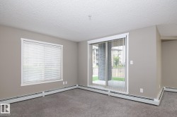 Room featuring neutral-toned walls, gray carpet flooring, and a textured white ceiling - 