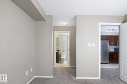 Carpeted interior space with light neutral wall tones and a textured ceiling - 