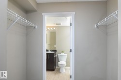 Walk-in closet with wire shelving and neutral wall paint, opening to a full bathroom - 