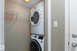 Dedicated laundry area with stackable washer and dryer, complemented by an overhead wire shelf for organization - 