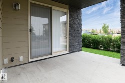 Concrete patio with stone accent wall and sliding glass door - 