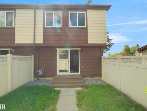 Rear exterior featuring brown siding with beige horizontal siding accents - 16 13833 30 Street, Edmonton, AB 