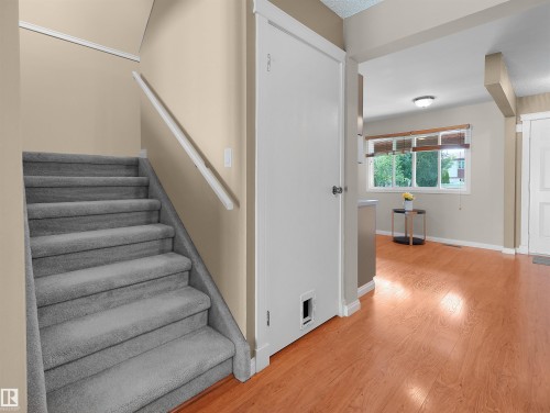 Staircase featuring grey carpeted treads and a white handrail - 16 13833 30 Street, Edmonton, AB 