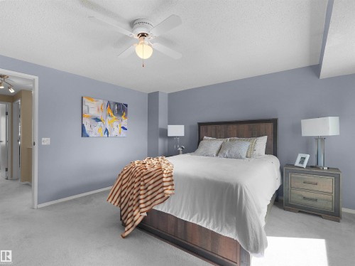 Spacious room featuring light blue painted walls, light-colored carpeting, and a ceiling fan with integrated lighting - 16 13833 30 Street, Edmonton, AB 