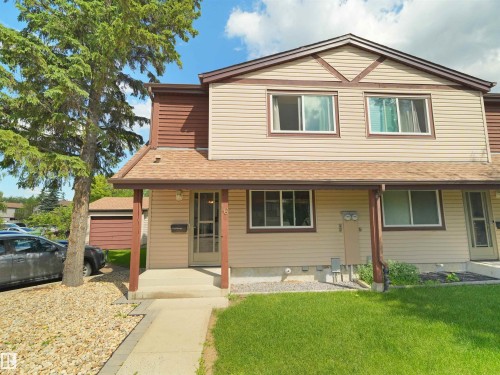 Two-story exterior featuring beige horizontal siding with brown trim and accents - 16 13833 30 Street, Edmonton, AB 