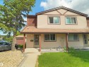 Two-story exterior featuring beige horizontal siding with brown trim and accents - 16 13833 30 Street, Edmonton, AB 