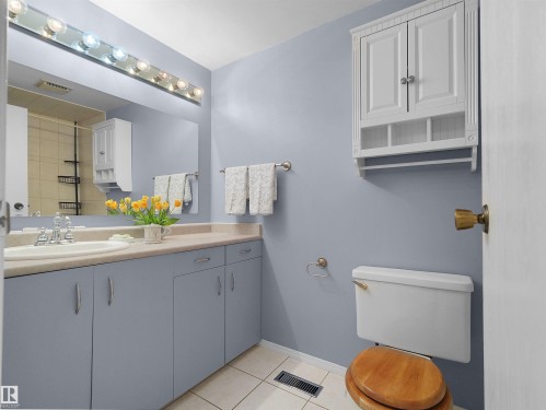 Bathroom featuring a vanity with a laminate countertop, integrated sink, and undermount cabinetry - 16 13833 30 Street, Edmonton, AB 