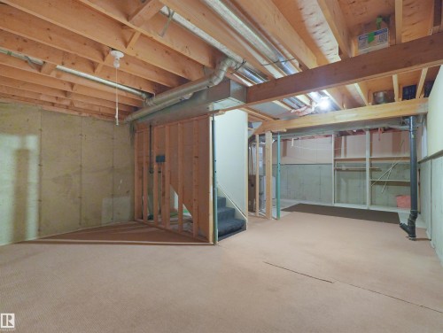 Expansive unfinished basement featuring exposed wood joists and concrete foundation walls - 16 13833 30 Street, Edmonton, AB 