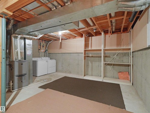 Unfinished basement featuring exposed wooden joists, concrete walls, and a utility area with mechanical systems - 16 13833 30 Street, Edmonton, AB 