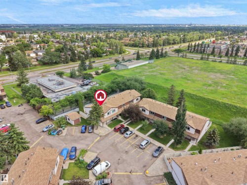 Aerial view of a residential complex featuring multiple buildings with brown shingle roofs - 16 13833 30 Street, Edmonton, AB 