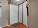 Entryway featuring a white paneled door with decorative trim, wood-finish flooring, and a flush mount ceiling light - 16 13833 30 Street, Edmonton, AB 