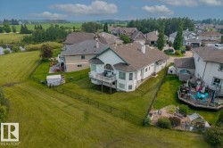 Spacious suburban property featuring a two-story residence with a white exterior and a prominent bay window - 