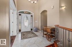 Entryway featuring a white door with decorative glass inserts, sidelights, and an arched transom - 